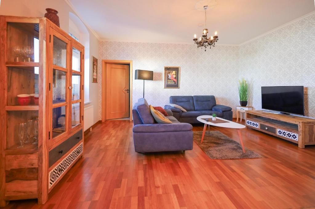 a living room with a blue couch and a tv at Bryza Homes - Villa Linde - Parkplatz - Ahlbeck - Patio in Ahlbeck
