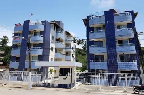 a blue building with a fence in front of it at Apartamento Ilhéus próximo à praia in Ilhéus
