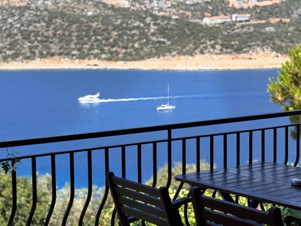 a balcony with a table and a boat in the water at Villa Noa Amazing Sea view in Kaş