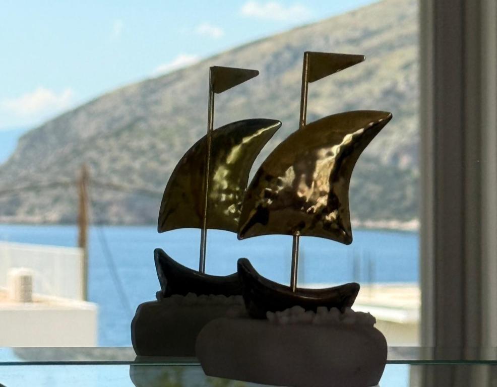 a bronze sculpture of two boats on a glass table at Pelekanos Apartment in Paralia Saranti