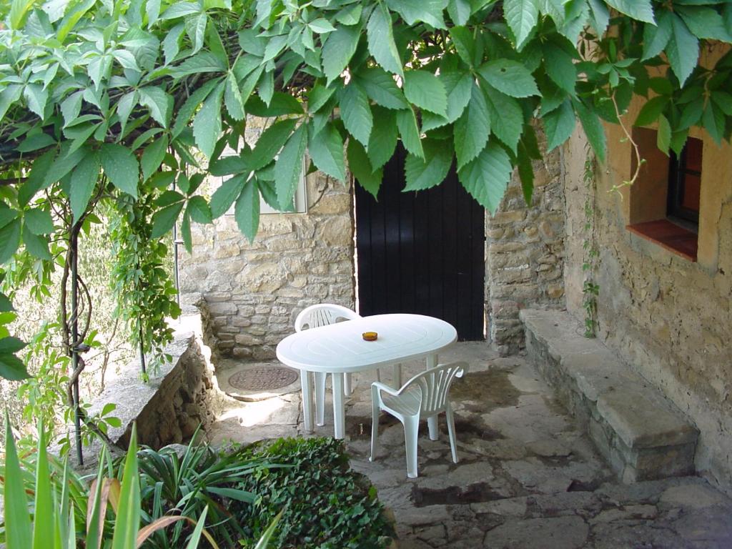 een witte tafel en twee stoelen onder een boom bij Cal Xeco in Montsonis