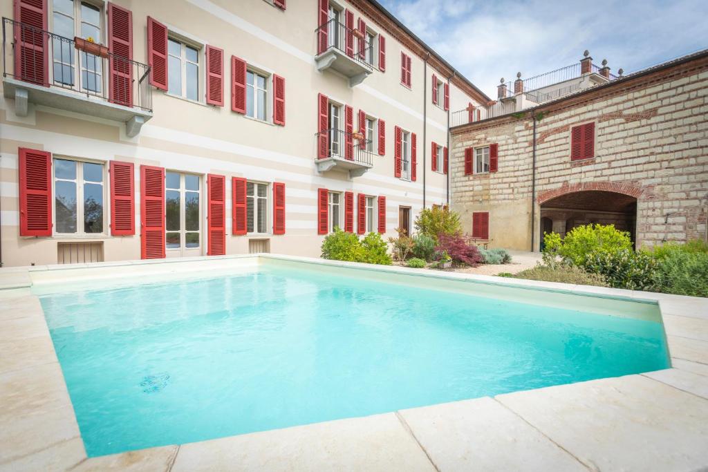 a swimming pool in front of a building at OLIVOLA APARTMENTS in Frassinello