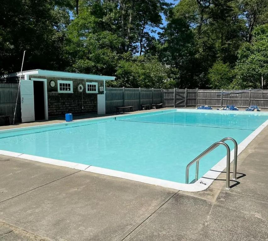 a large swimming pool with a house in the background at The Salty Dolphin - DEN - DW7 in Dennis