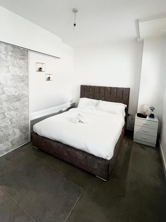 a bedroom with a large bed with white sheets at Digbeth Luxury 1 Bed Studio Apartment in Birmingham