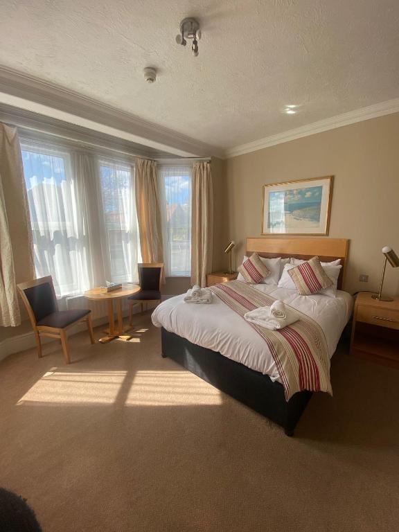a bedroom with a large bed and some windows at The Windsor House Hotel in Worthing