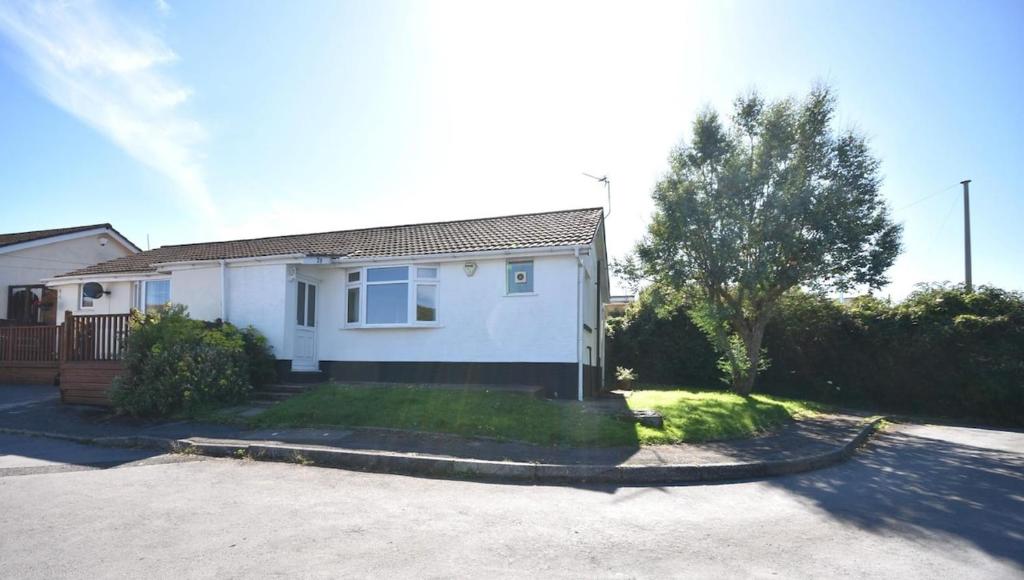 a white house with a driveway in front of it at Bungalow in Mumbles in The Mumbles
