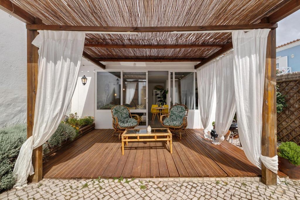 a wooden deck with chairs and a table at Casa Do Canto in Cascais