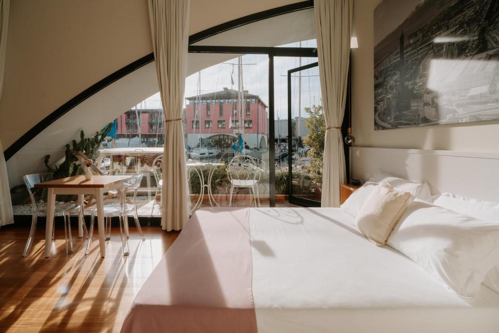 a bedroom with a white bed and a large window at Locanda da Toto in Genoa