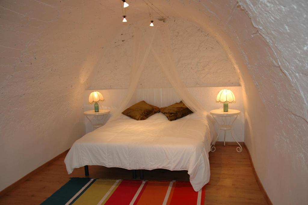 a bedroom with a bed with two lamps on two tables at Cal Valeriet in Montsonis