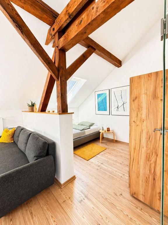a living room with a couch and wooden beams at Ferienwohnung Nikolaiblick in Stralsund