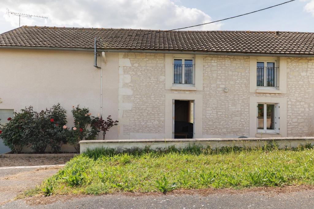 a brick house with a yard in front of it at Gîte La Chapelière in Assay
