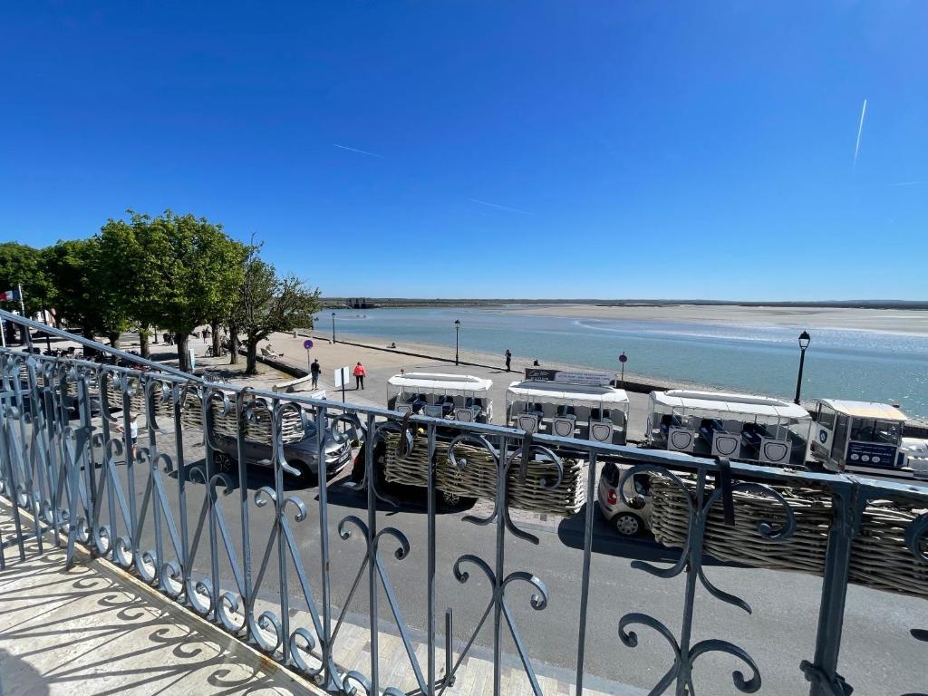 a view of a beach with a fence and water at Villa des Sarcelles in Le Crotoy