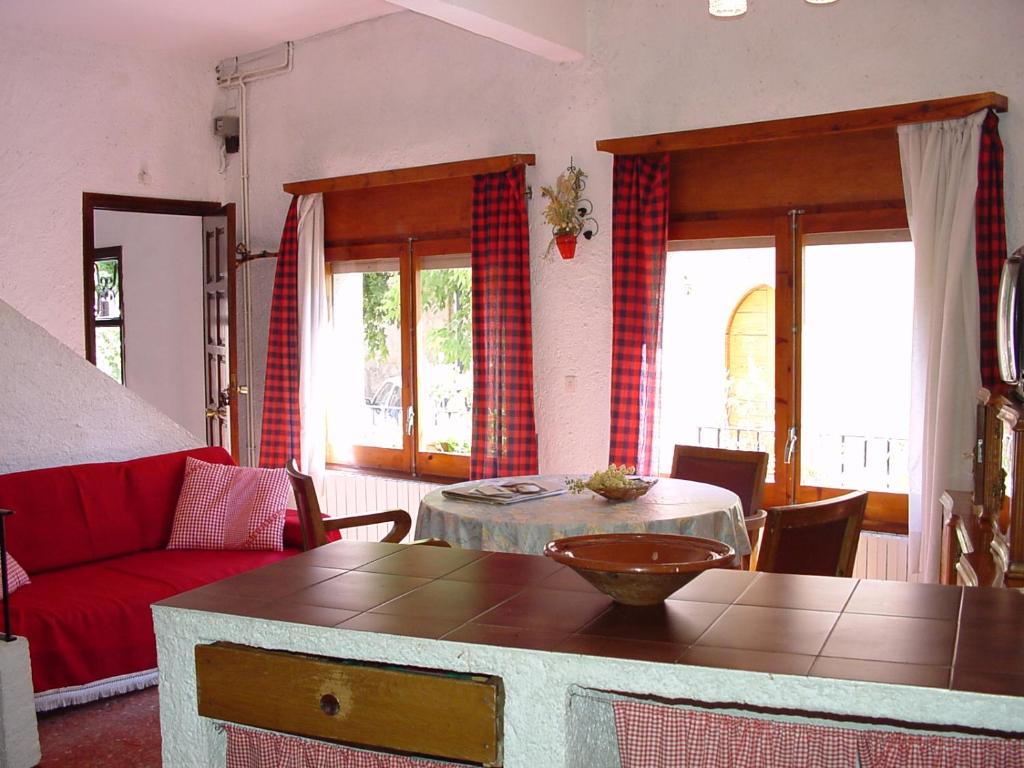 a living room with a red couch and a table at Cal Gravat in Montsonis