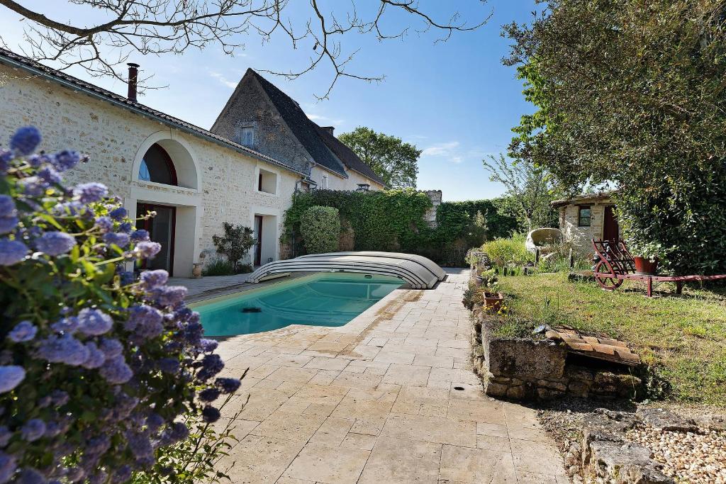a swimming pool in a yard next to a house at Gite À La Tite Boulite in Vouneuil-sous-Biard