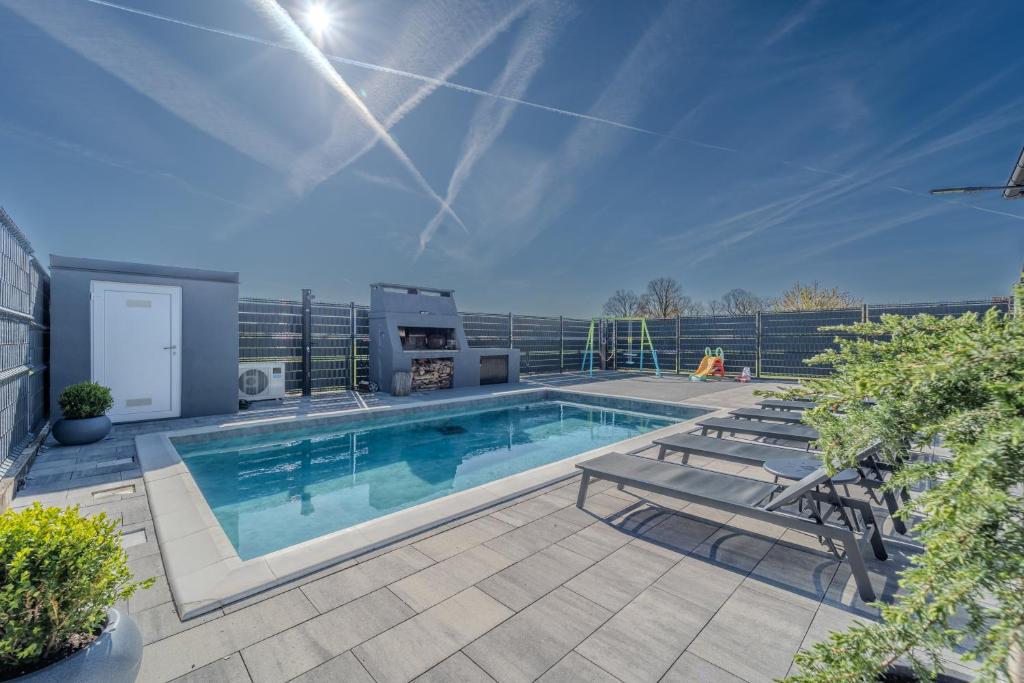a swimming pool with two picnic tables and two chairs at Holiday Villa Pervan in Sesvete