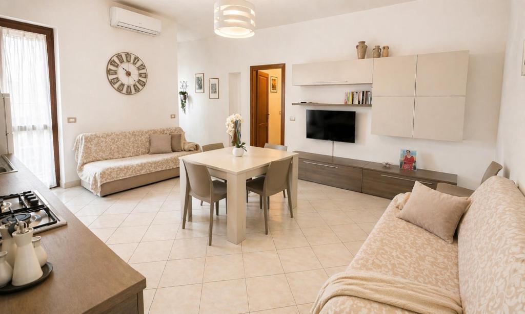 a living room with a couch and a table with chairs at Casa Rosada Alghero in Alghero