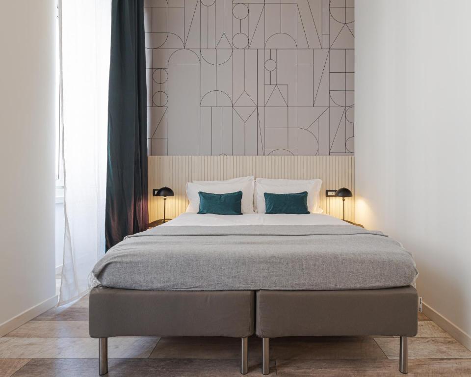 a bedroom with a large bed with two pillows at Rooms Boutique Carducci in Trieste