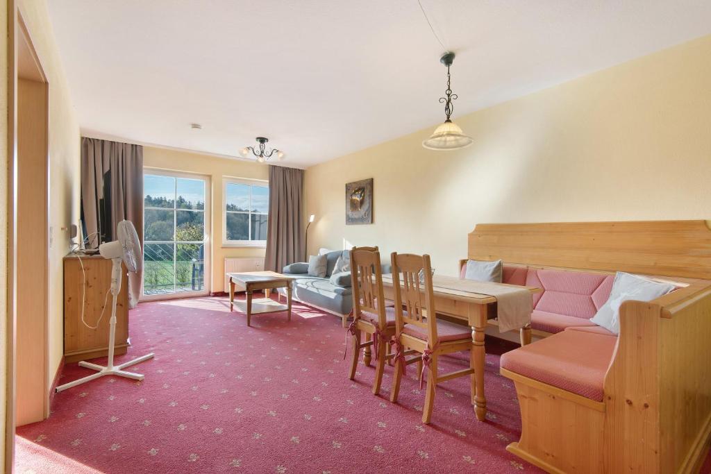 a living room with a table and a couch at Superior Apt mit Seeblick K2 002 in Spalt