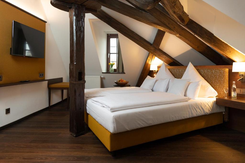 a bedroom with a bed and a tv on a wall at Altstadthotel Arch in Regensburg