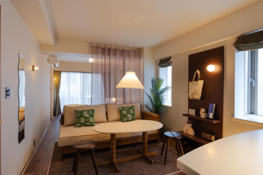 a living room with a couch and a table at The Apartment Hotel Shibuya 3 in Tokyo