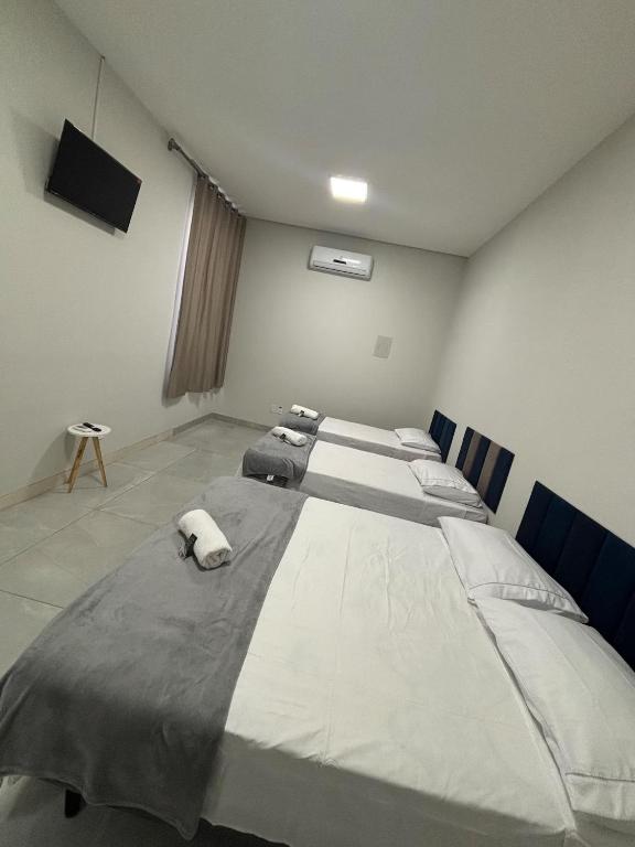a room with three beds in it with a television at Quartos Sinop in Sinop