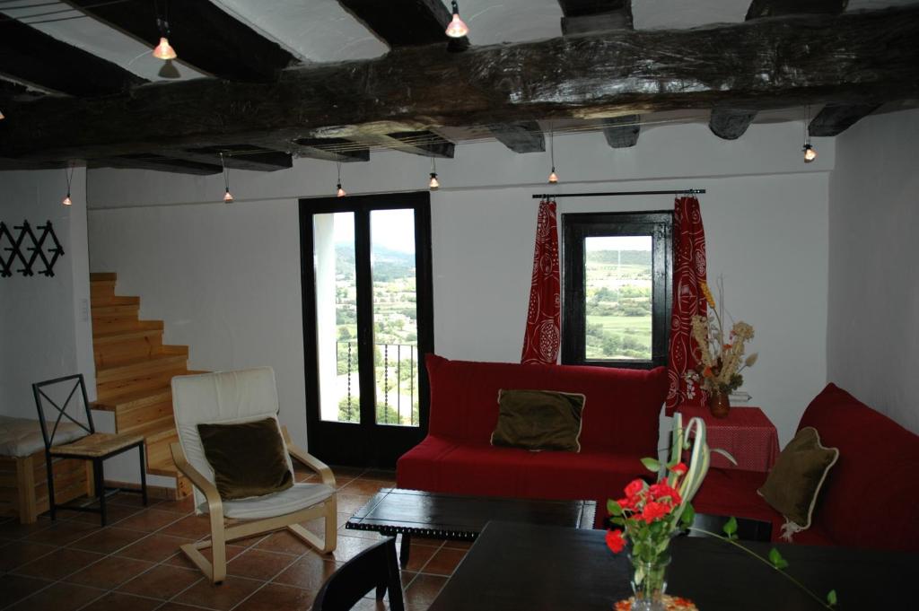 un soggiorno con tavolo e sedie rosse di Cal Valeri a Montsonis