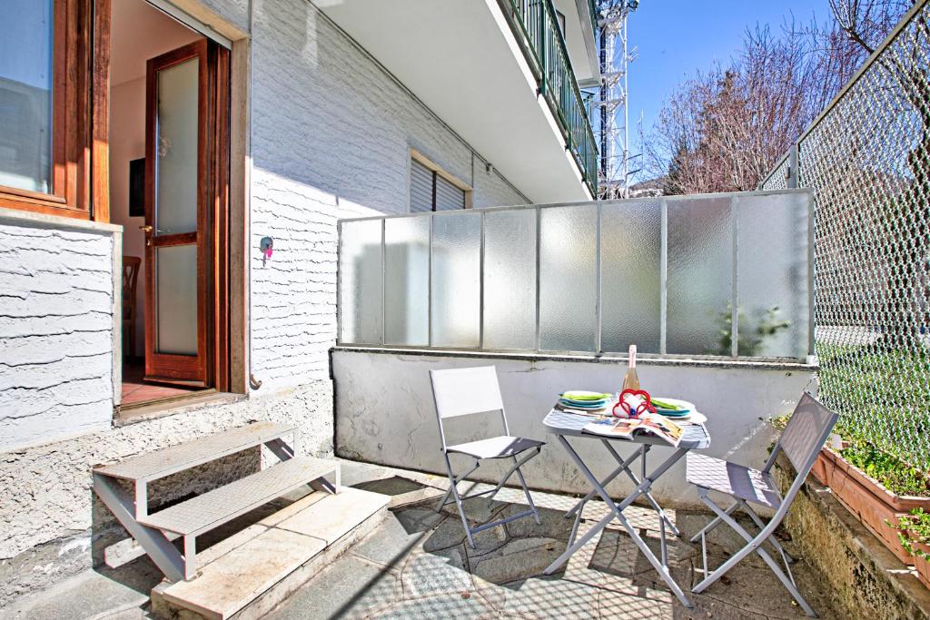 a patio with a table and chairs and a fence at Bardonest - Central Studio in Bardonecchia - Happy Rentals in Bardonecchia