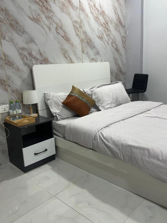 a bedroom with a bed with a nightstand next to it at The friendly stay in Male City