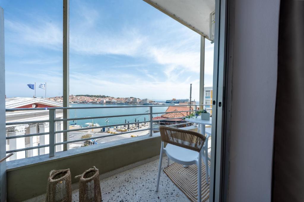 a balcony with a chair and a view of the water at Aether View Premium Views in Central Mytilene in Mytilene