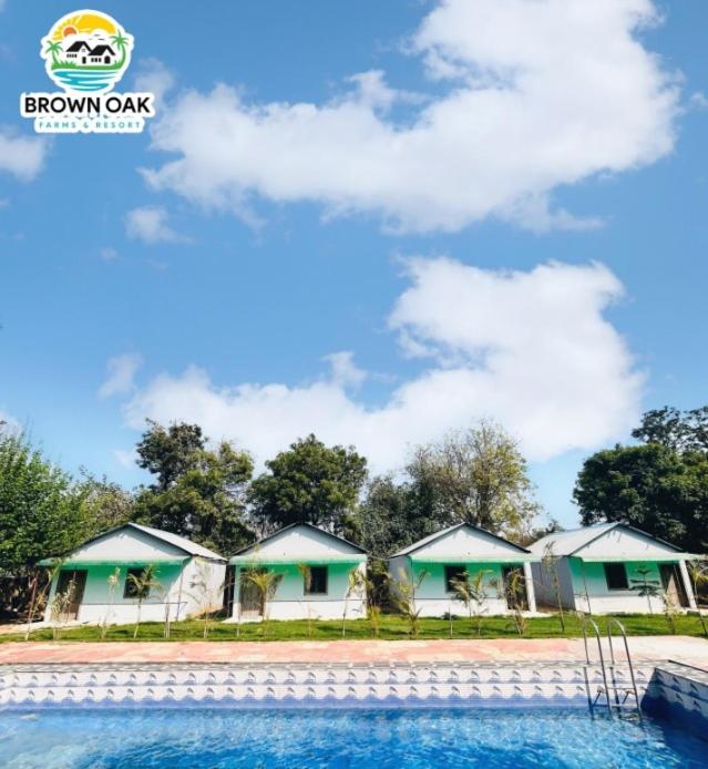 a row of houses in front of a pool at Brown oak farms in Sohna