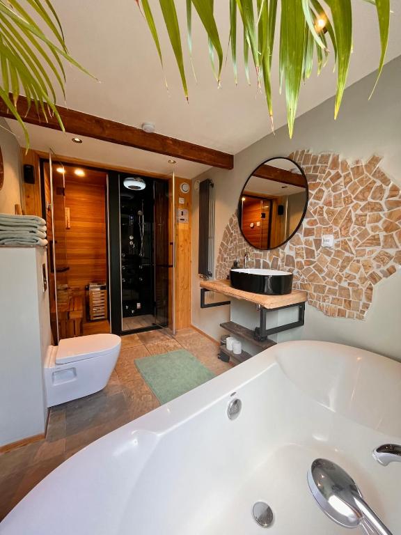 a bathroom with a tub and a sink at Spoor 2 met Wellness in Nieuwe Vaart