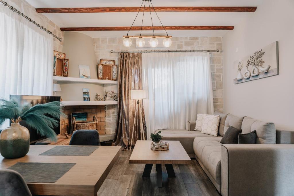 a living room with a couch and a table at Guince House by All About Paxos in Oziás