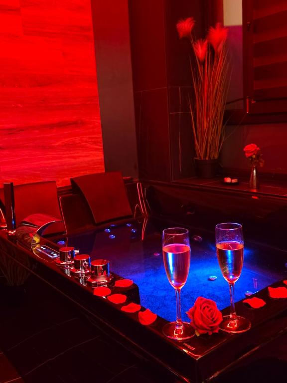 a bar with two glasses of wine and roses at Chambre de charme, sauna, jacuzzi,billard VIP, clim in Verviers