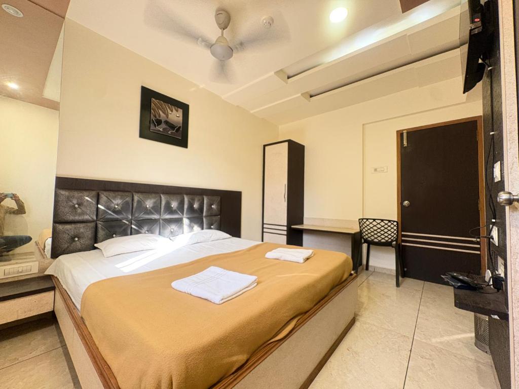 a bedroom with a large bed with two towels on it at Hotel Falcon Ulhasnagar by Hotelist in Kalyan