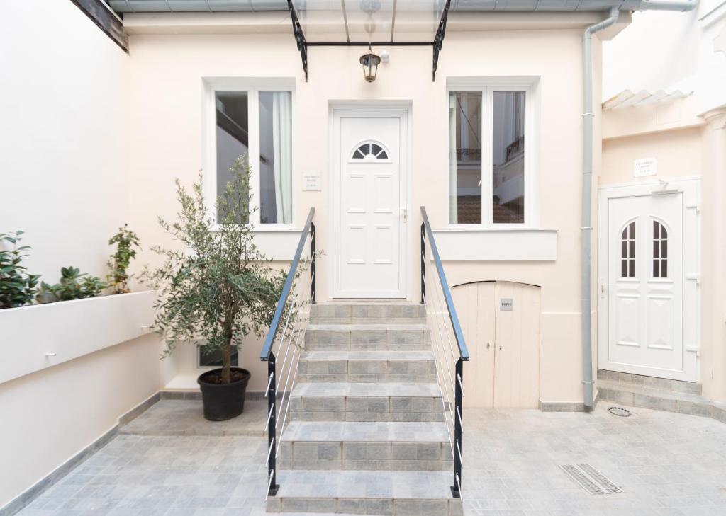 a house with a staircase leading to the front door at Hôtel De La Gare in Villeneuve-Saint-Georges
