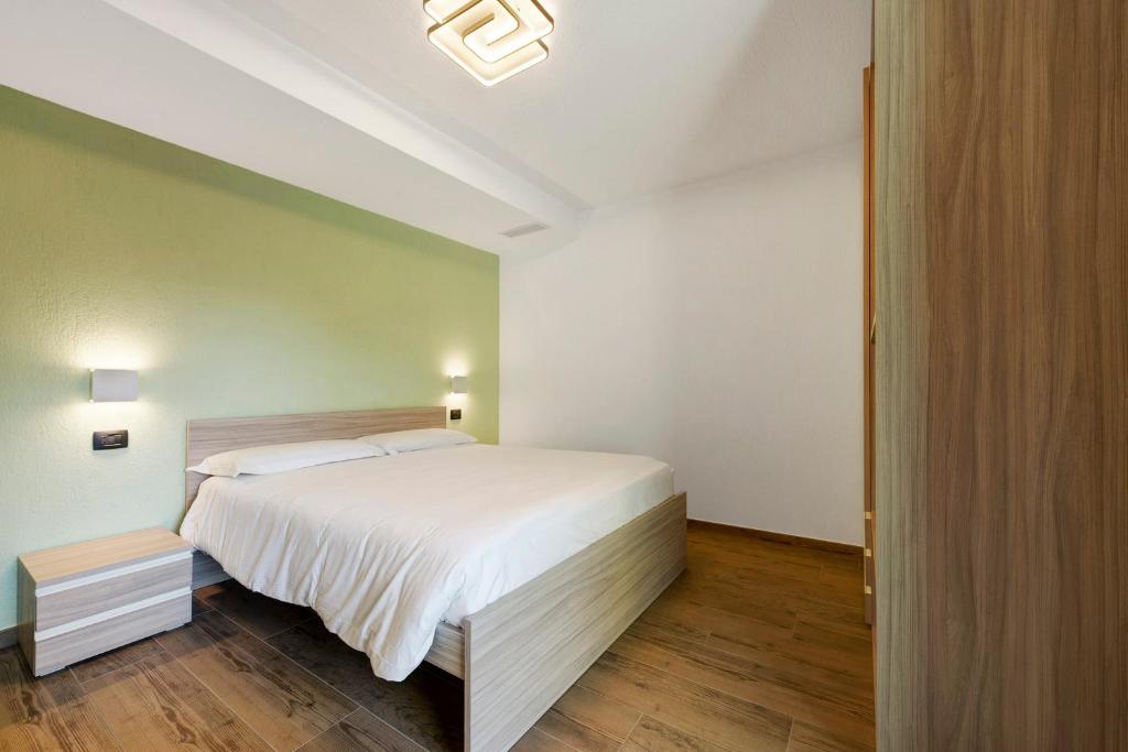 a bedroom with a large white bed and wooden floors at Appartamenti Suly 2 - Cir0083 in Saint Vincent