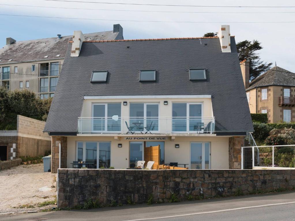 a house with a stone retaining wall at Gites Au Point De Vue in Perros-Guirec