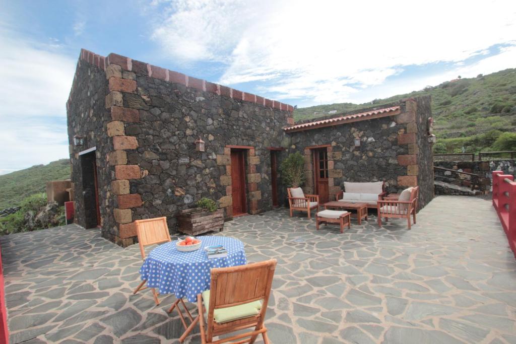 patio ze stołem i krzesłami oraz budynek w obiekcie Casa Rural la Hojalata w mieście Mocanal