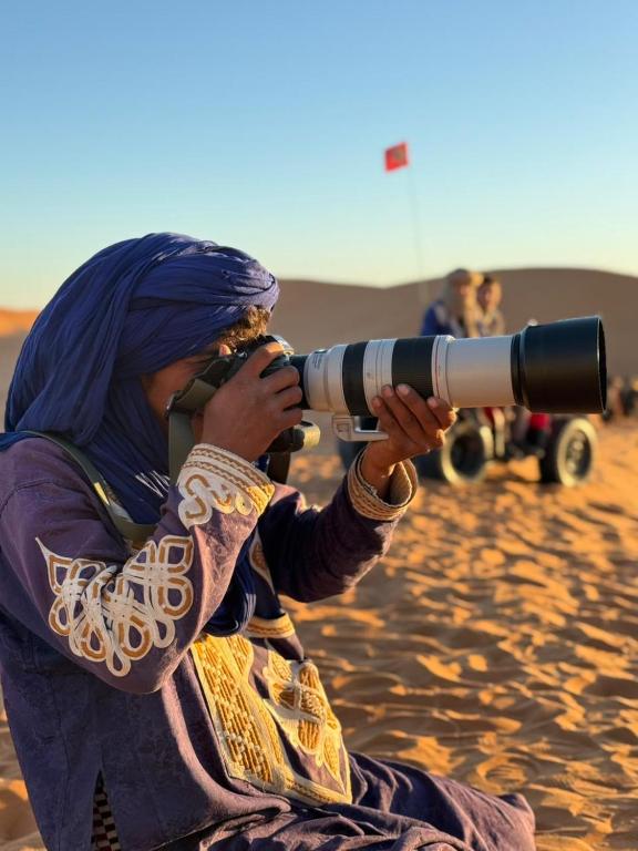 a woman looking through a camera with a telescope at Sahara Standard Camp in Merzouga