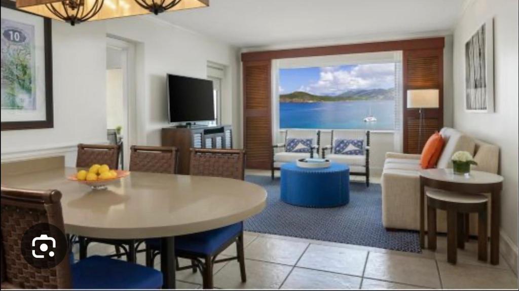 a living room with a table and a couch and a television at Saint Thomas Villa with Ocean view in Frenchmans Reef Heliport