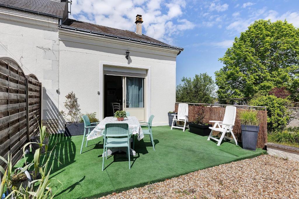 a patio with a table and chairs on a lawn at Gîte La Salamandre in Mosnes