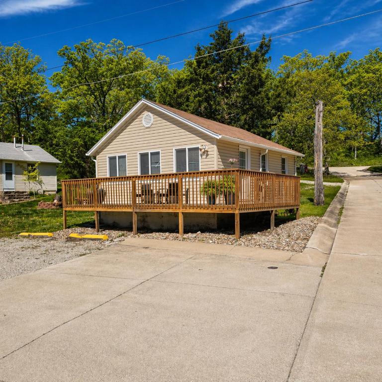 a house with a wooden deck on a driveway at Buccaneer Bay Bungalow #6 in Sunrise Beach