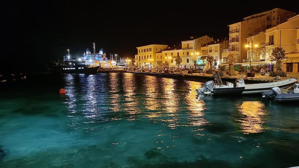 a river at night with buildings and a boat in the water at Perla di mare in La Maddalena