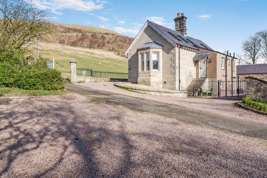 an old house on a dirt road next to a building at 3 Bed in Langholm oc-c41365 in Langholm