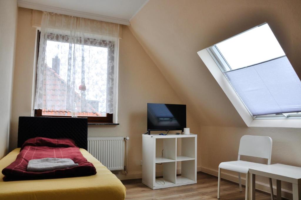 a bedroom with a bed and a tv and a window at Pension Highway - Bünde Borriesstraße 39 in Bünde