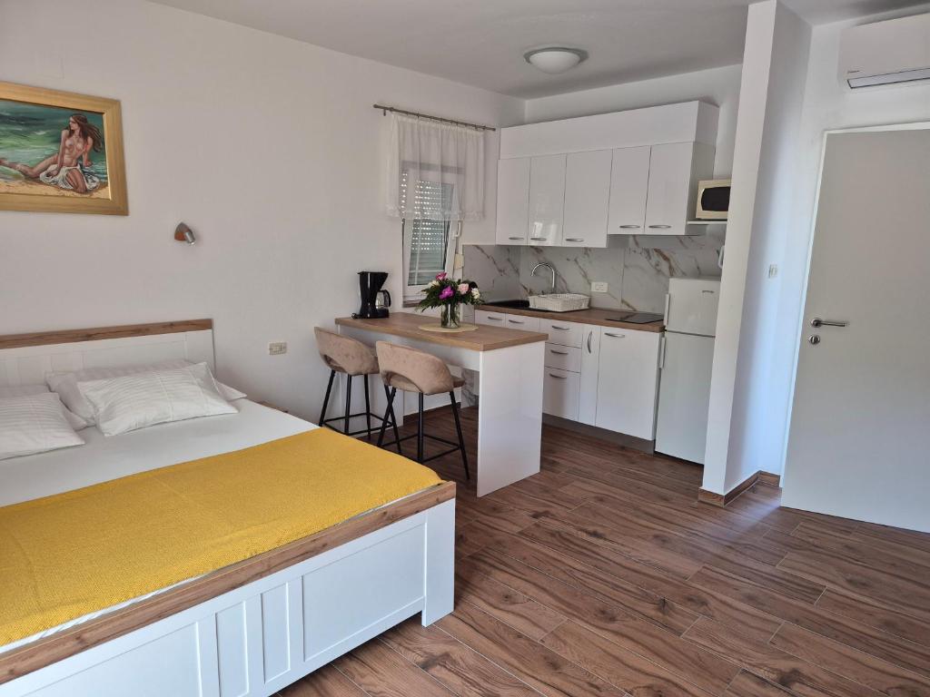 a small bedroom with a bed and a kitchen at Apartments Ivanovski in Rab