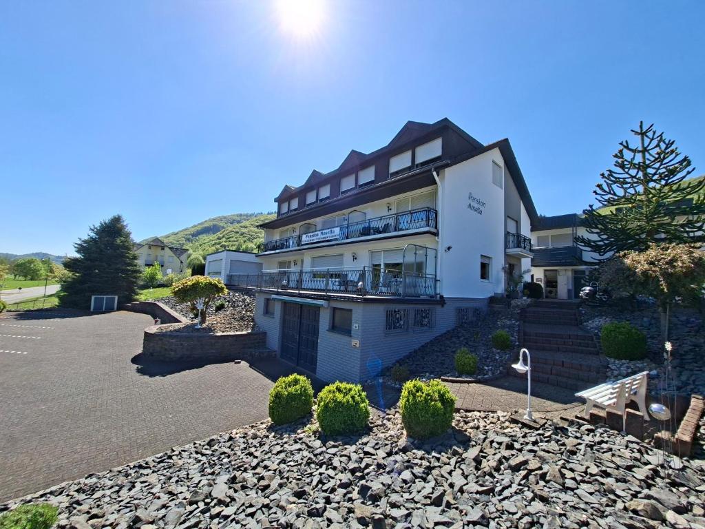 a large white building with a parking lot at Pension Mosella , Appartement-Wohnung mit Balkon und Moselblick in Sankt Aldegund
