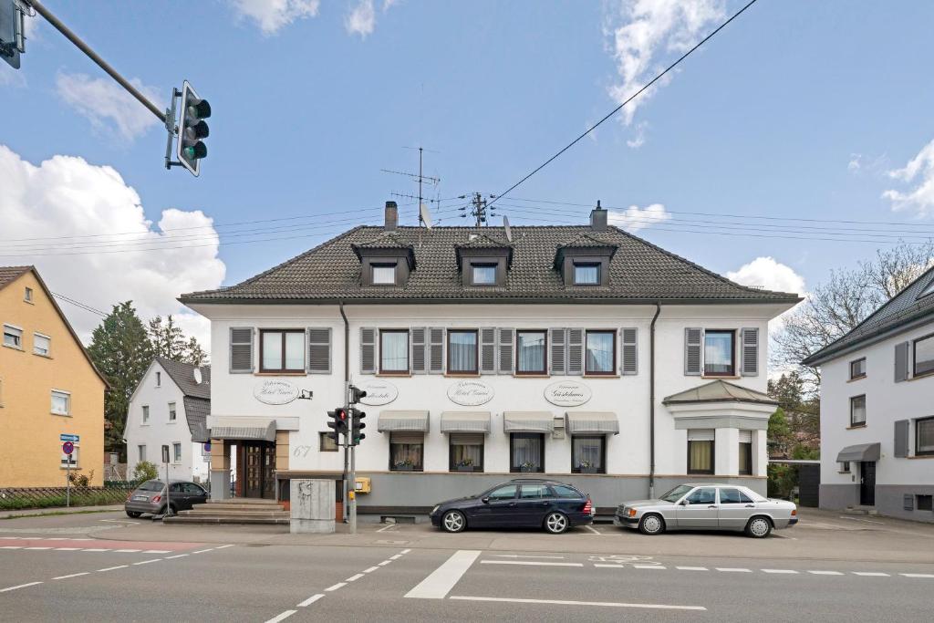 a large white building with cars parked in front of it at Hotel Garni Siedlerstube 2 in Nürtingen