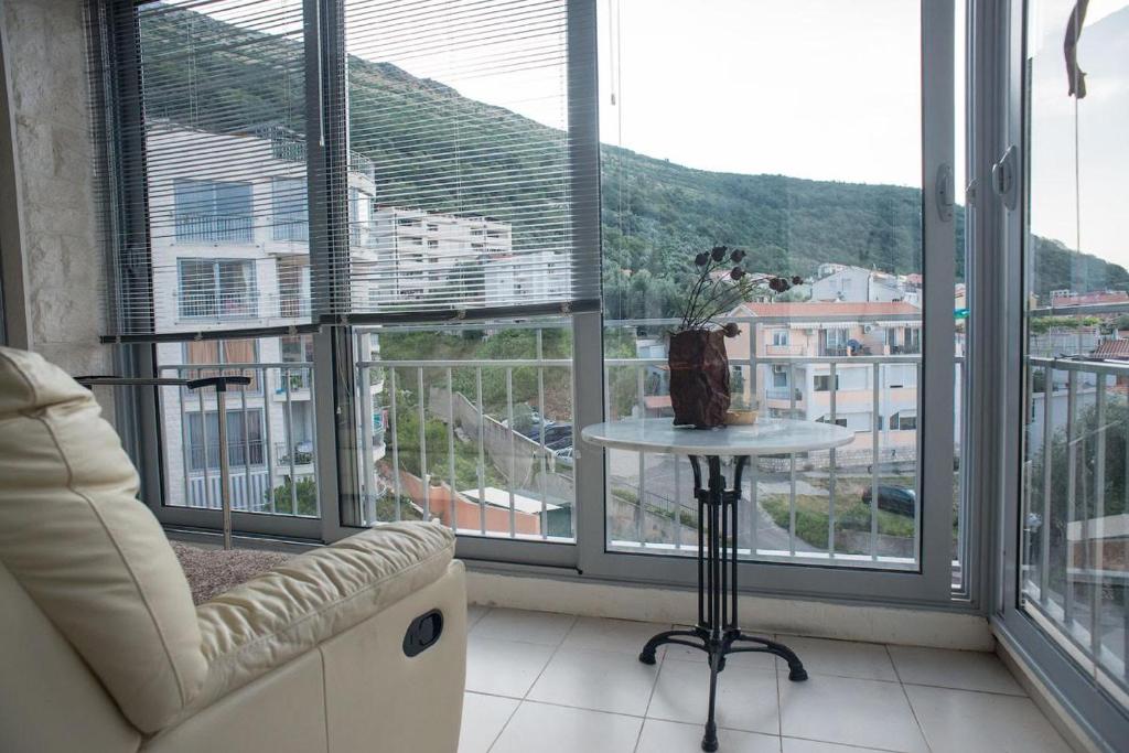 a room with a couch and a table and windows at Cozy home in Petrovac na Moru
