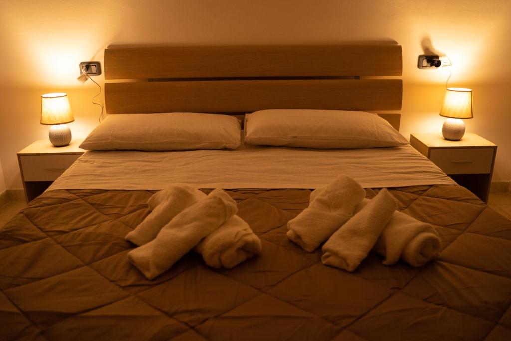 a bed with three towels on it with two lamps at Al Civico 23 in Castiglione del Lago